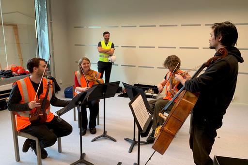 Akustiktest i rumrepliken. En grupp studenter spelar stråkinstrument.